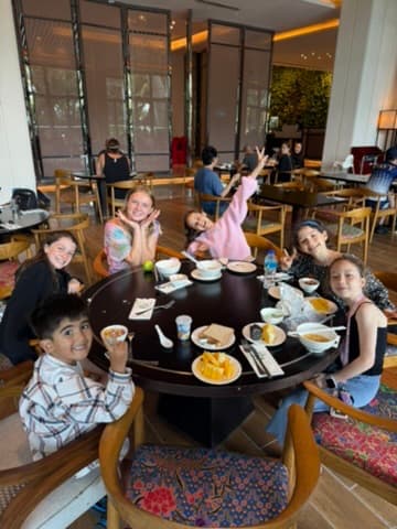 Children gathered around a round table sharing a meal together