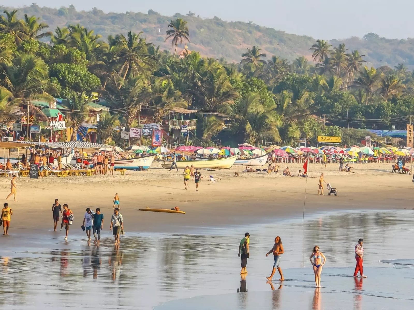 A lively Goa beach with fishing boats pulled up on the sand